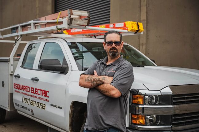 Esquared Electric electrician standing beside a company service truck